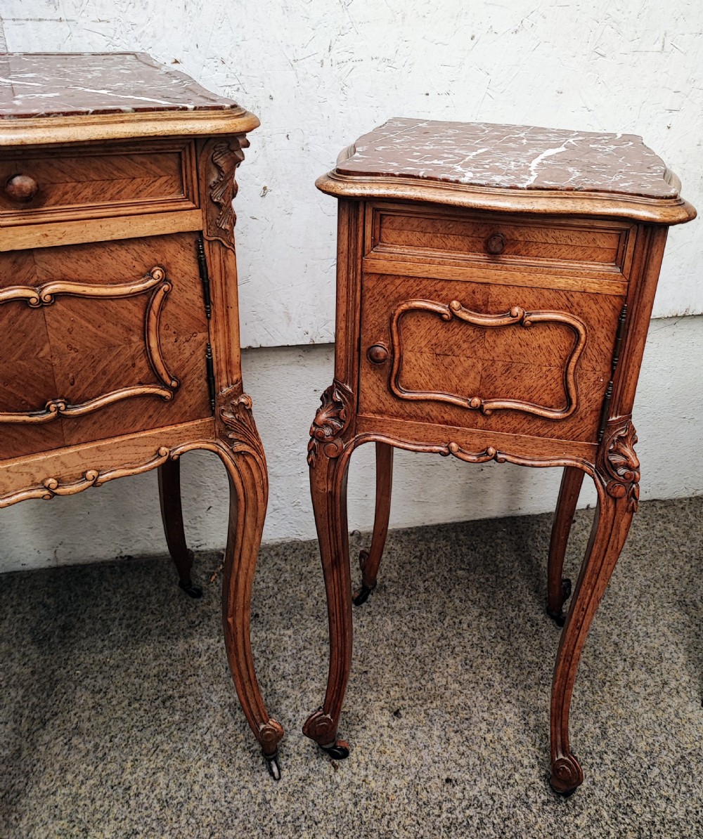 An antique matched pair of French marble top bedside cabinets.  View XVI
