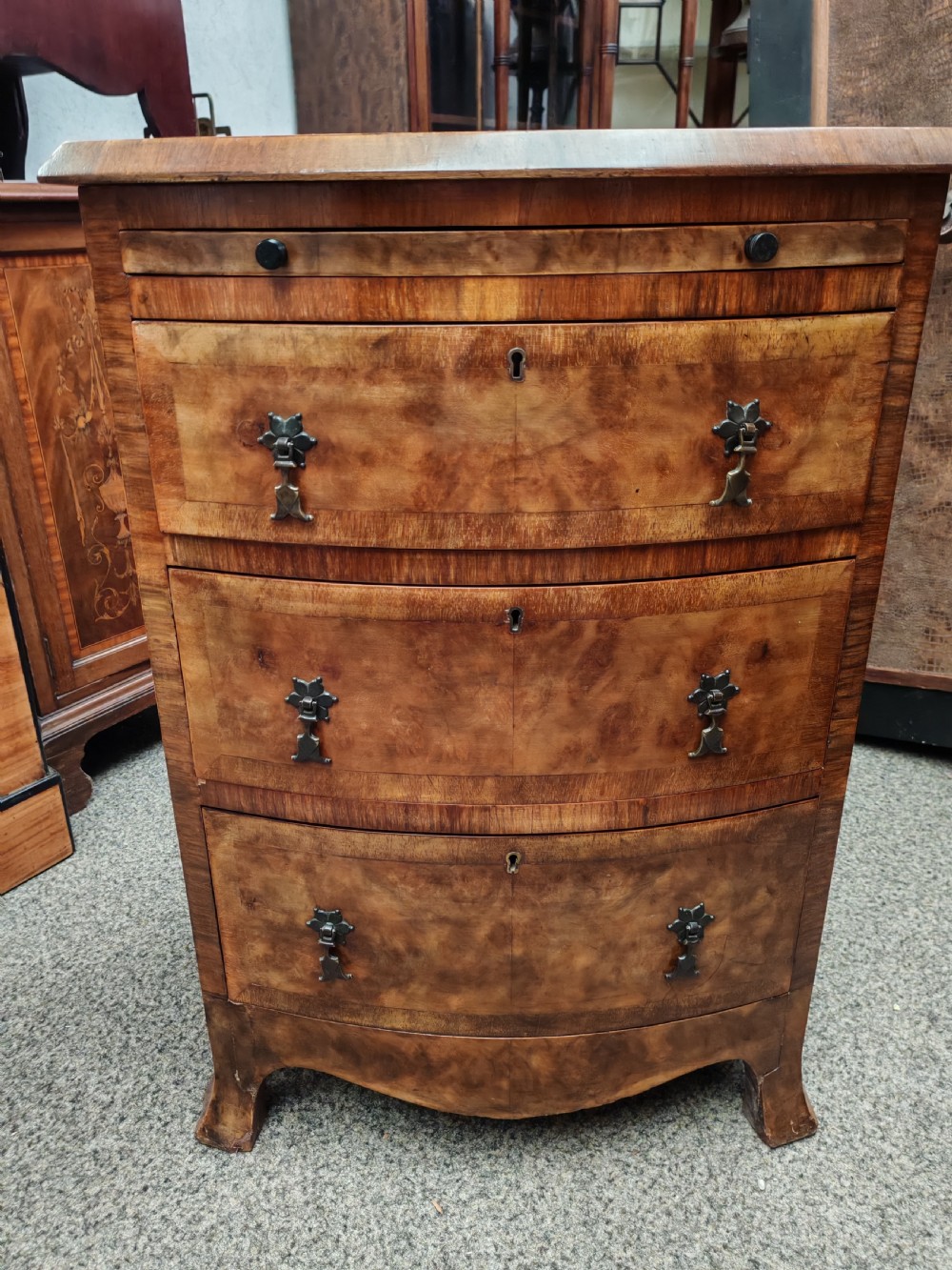 Antique, small walnut bow front chest with brushing slide.