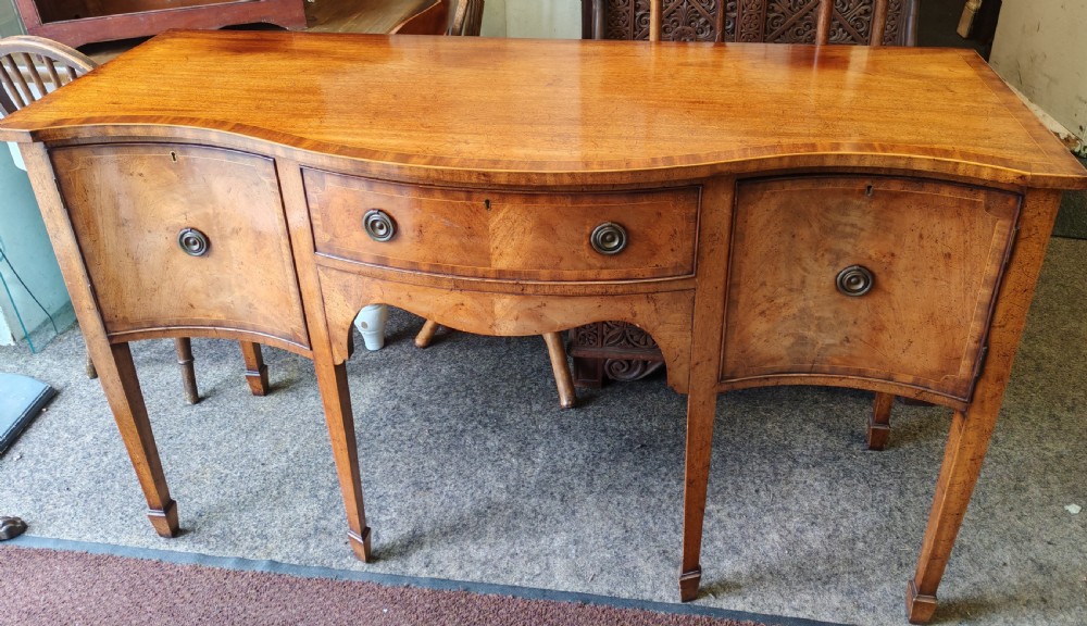 Antique mahogany, serpentine and inlaid sideboard in the George III style.