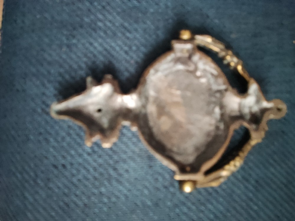 A cast brass Neoclassical style door knocker shaped like an urn with a floral patterned hinged ring. View V