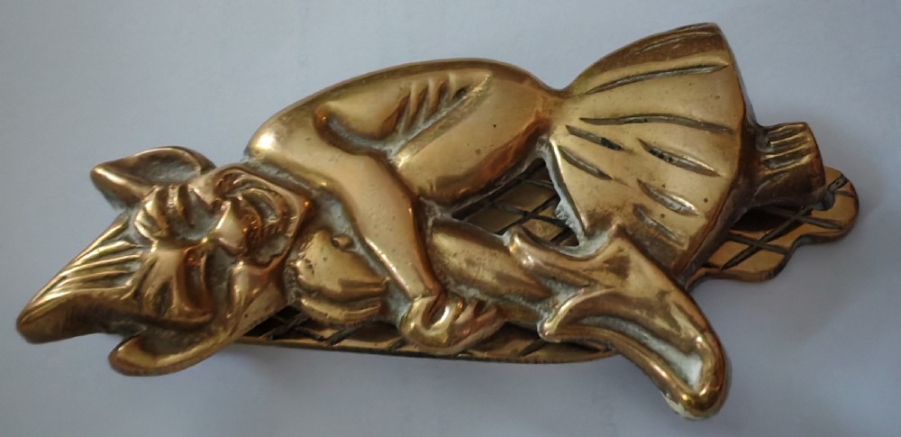 A cast brass door knocker depicting a seated imp perched upon a toadstool with pointed ears and knees drawn up. View VIII