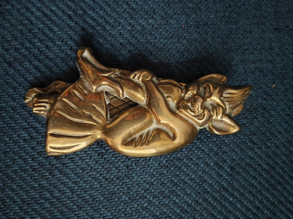 A cast brass door knocker depicting a seated imp perched upon a toadstool with pointed ears and knees drawn up. View XI