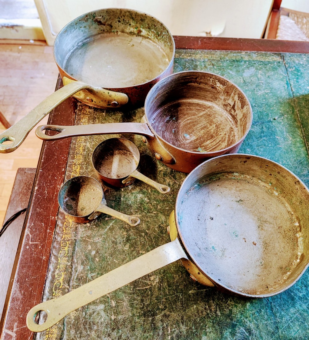 A set of five Victorian graduated copper saucepans featuring cast brass handles secured with heavy copper rivets. View III