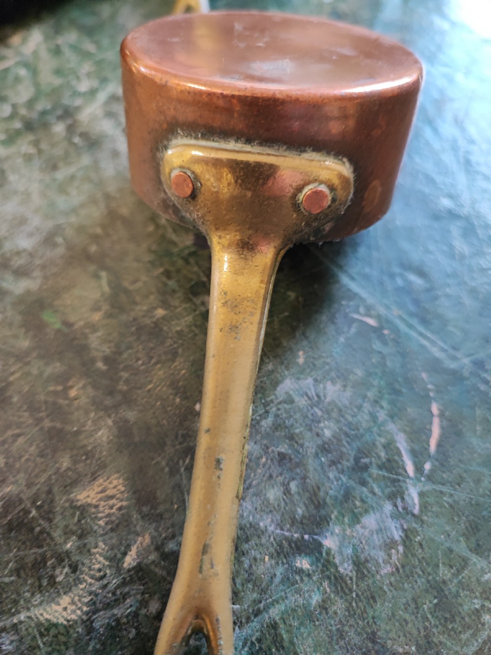 A set of five Victorian graduated copper saucepans featuring cast brass handles secured with heavy copper rivets. View IV