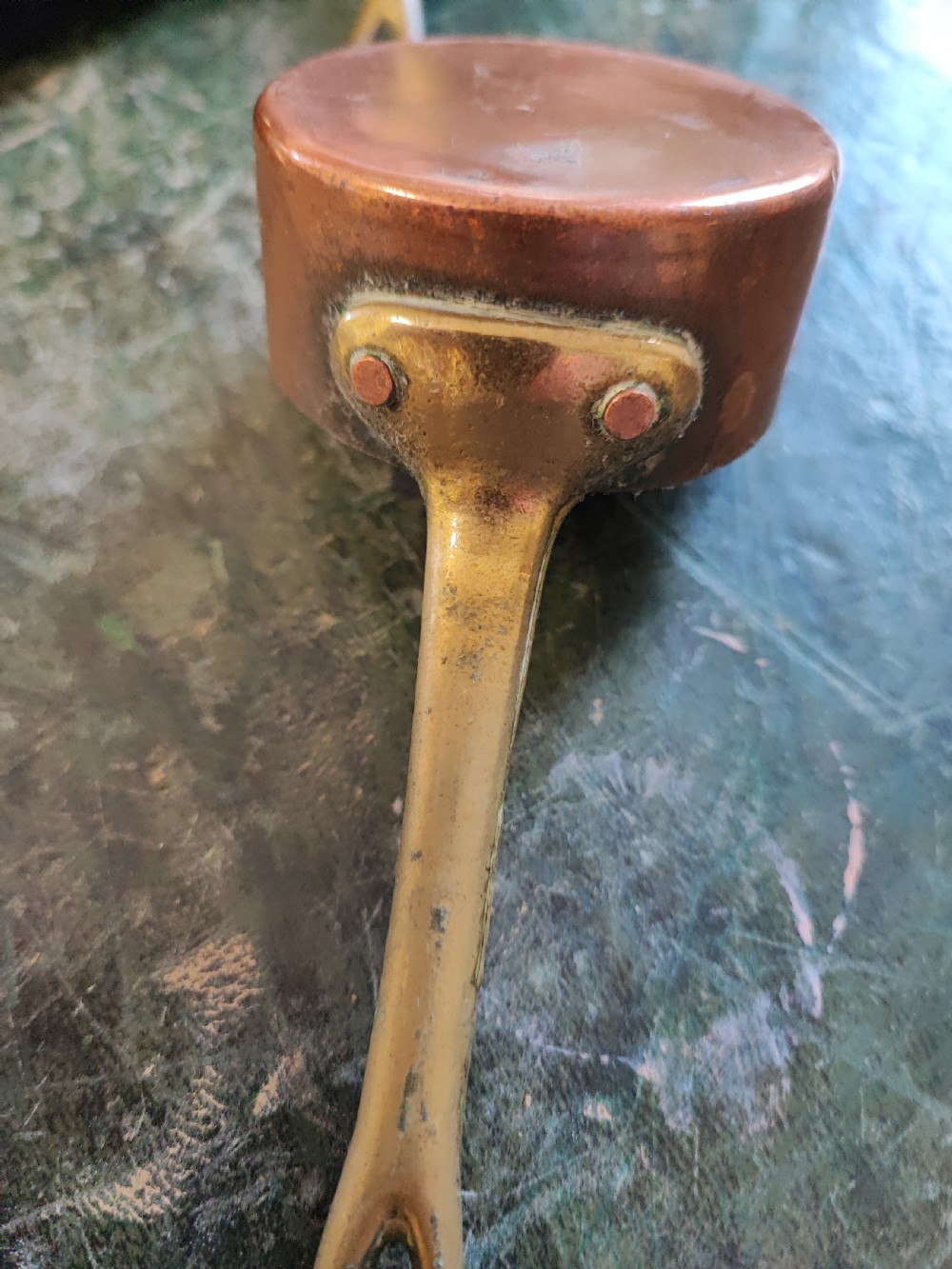 A set of five Victorian graduated copper saucepans featuring cast brass handles secured with heavy copper rivets. View V