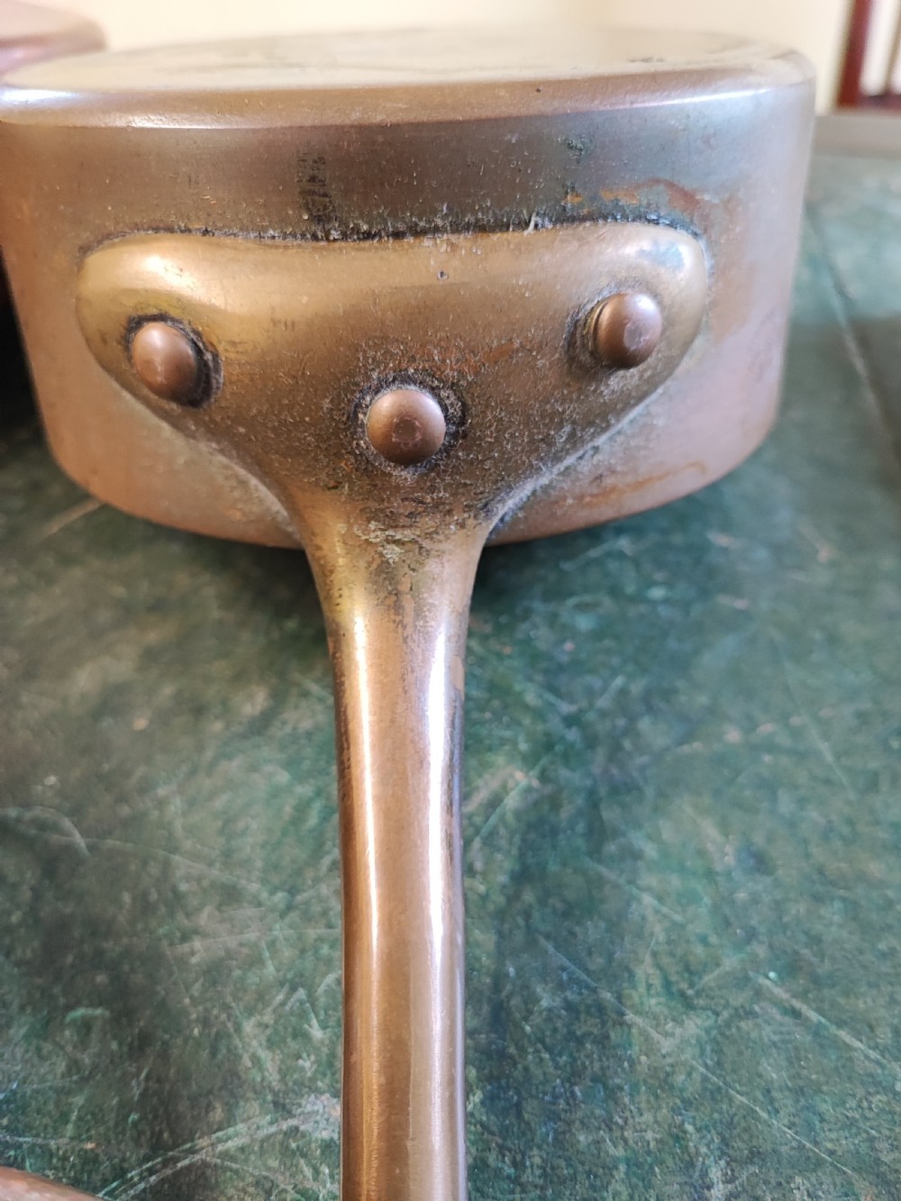 A set of five Victorian graduated copper saucepans featuring cast brass handles secured with heavy copper rivets. View VI