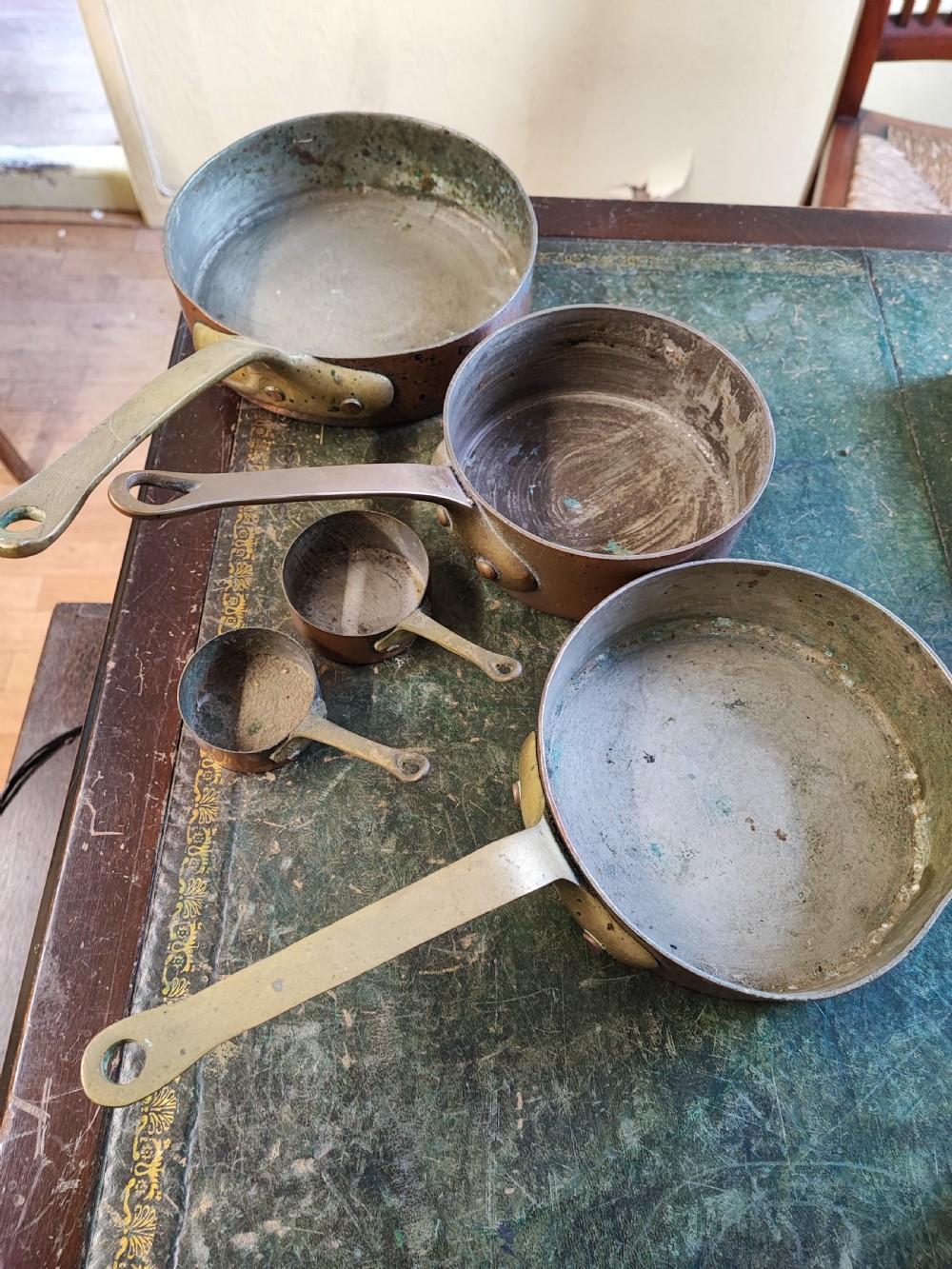 A set of five Victorian graduated copper saucepans featuring cast brass handles secured with heavy copper rivets. View VII