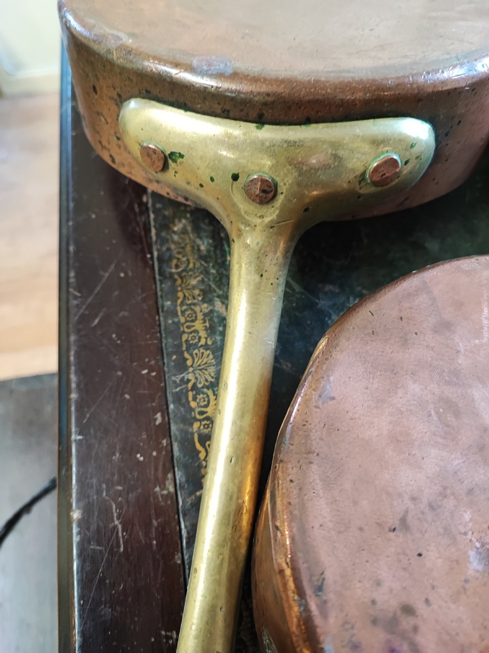 A set of five Victorian graduated copper saucepans featuring cast brass handles secured with heavy copper rivets. View IX