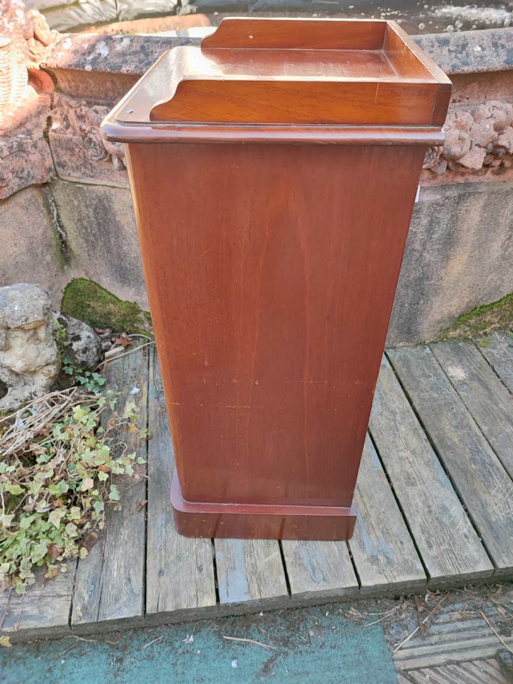 A tall Victorian mahogany bedside cabinet featuring a gallery top, a single recessed panel door with a wooden turned knob, and a solid plinth base. View II