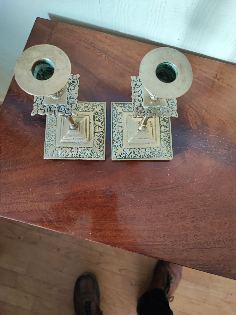 A matching pair of Victorian brass candlesticks featuring square relief bases, ribbed stems, square drip trays, and turned sconces. View III