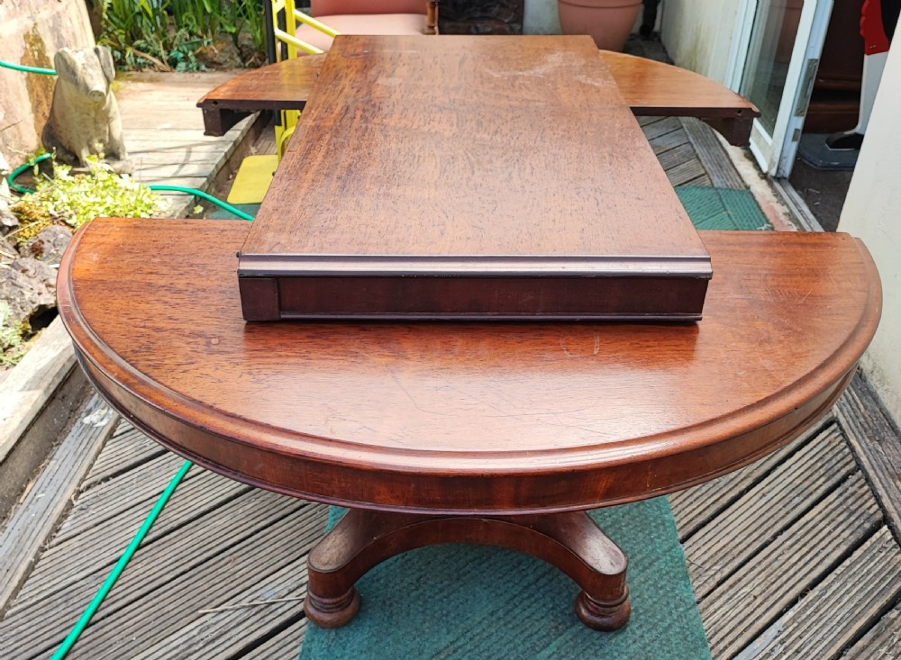 Antique mahogany circular extending dining table.