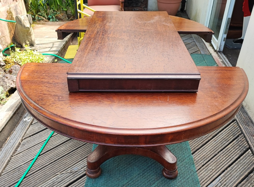 Antique mahogany circular extending dining table. View XI