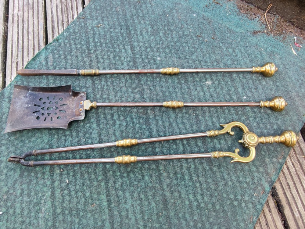 A superb set of antique brass and iron fire irons.
