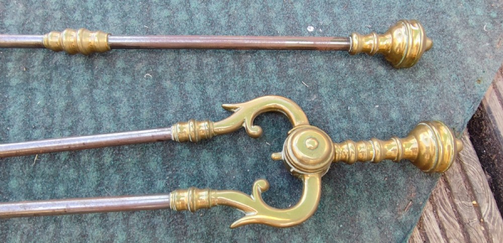 A superb set of antique brass and iron fire irons. View VI