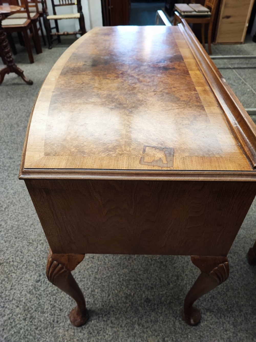 An antique golden burr walnut dressing table with five drawers, brass drop handles, and cabriole legs. View III