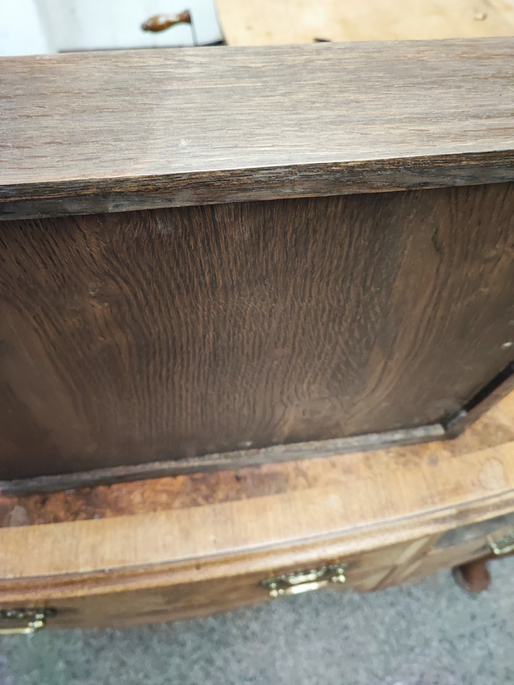 An antique golden burr walnut dressing table with five drawers, brass drop handles, and cabriole legs. View V