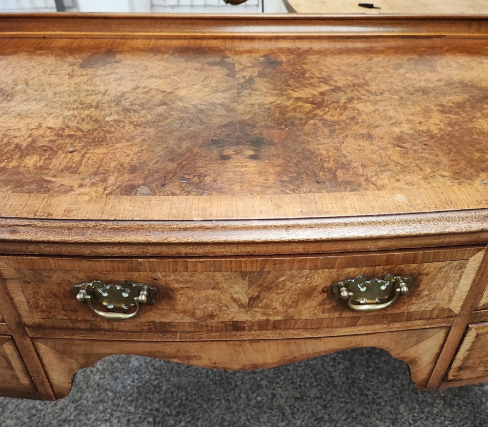 An antique golden burr walnut dressing table with five drawers, brass drop handles, and cabriole legs. View VIII