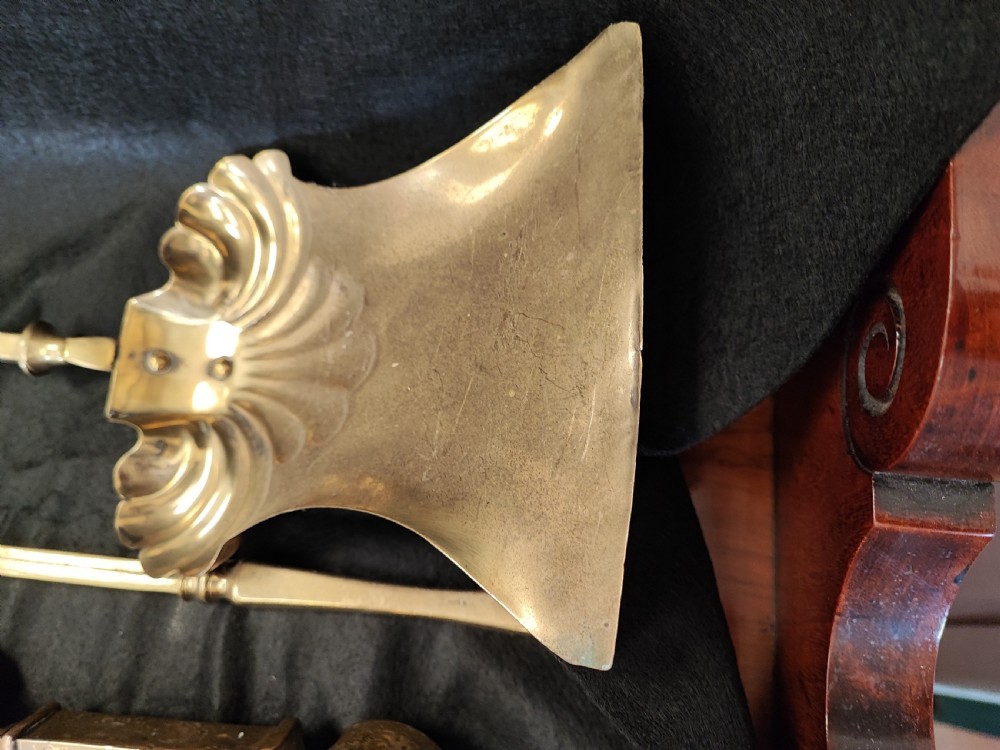 A set of three antique solid brass fire irons comprising a poker, tongs, and a shovel with a decorative shell pan. View VII