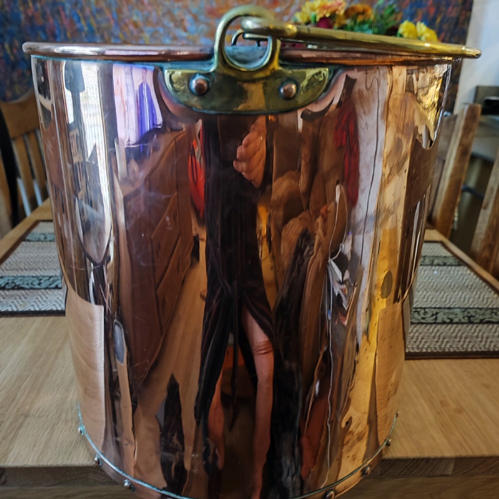 A cylindrical polished copper bucket featuring a riveted vertical seam, a rolled brass rim, and a band of rivets around the base. View II
