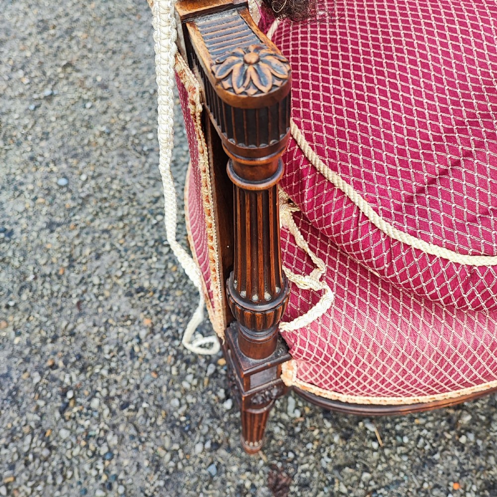 An antique French Louis XVI style wingback armchair crafted from mahogany with patterned red textile upholstery and fluted legs. View II
