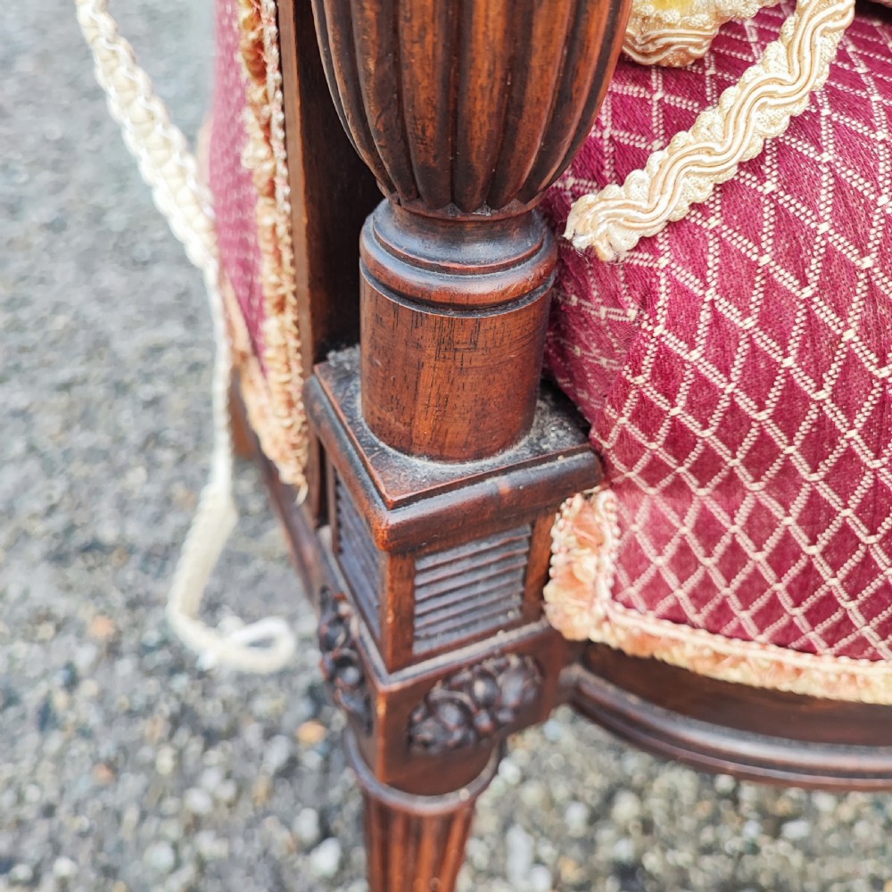An antique French Louis XVI style wingback armchair crafted from mahogany with patterned red textile upholstery and fluted legs. View III