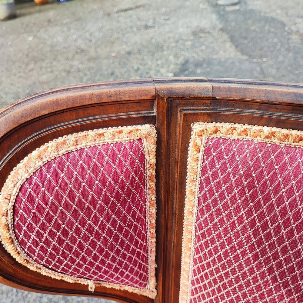 An antique French Louis XVI style wingback armchair crafted from mahogany with patterned red textile upholstery and fluted legs. View IX