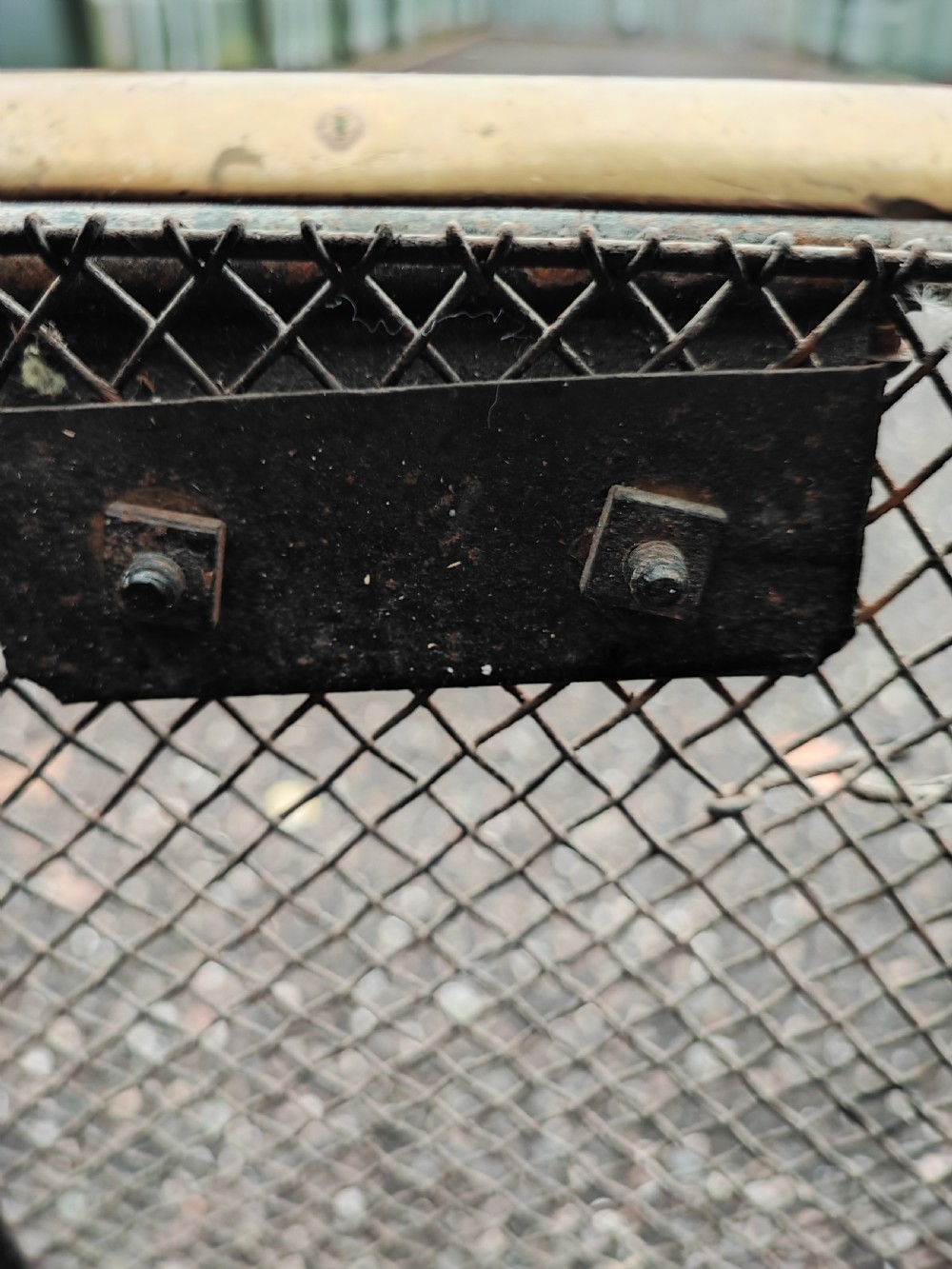 An antique nursery fireguard with a black woven wire mesh body, curved sides, and an upper tubular brass rail. View IX