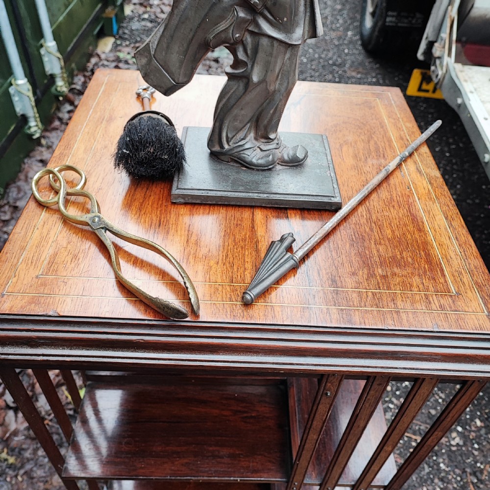A dark cast metal companion set stand depicting a golfer caddy holding a flag pole and carrying a golf bag on a rectangular base. View VIII