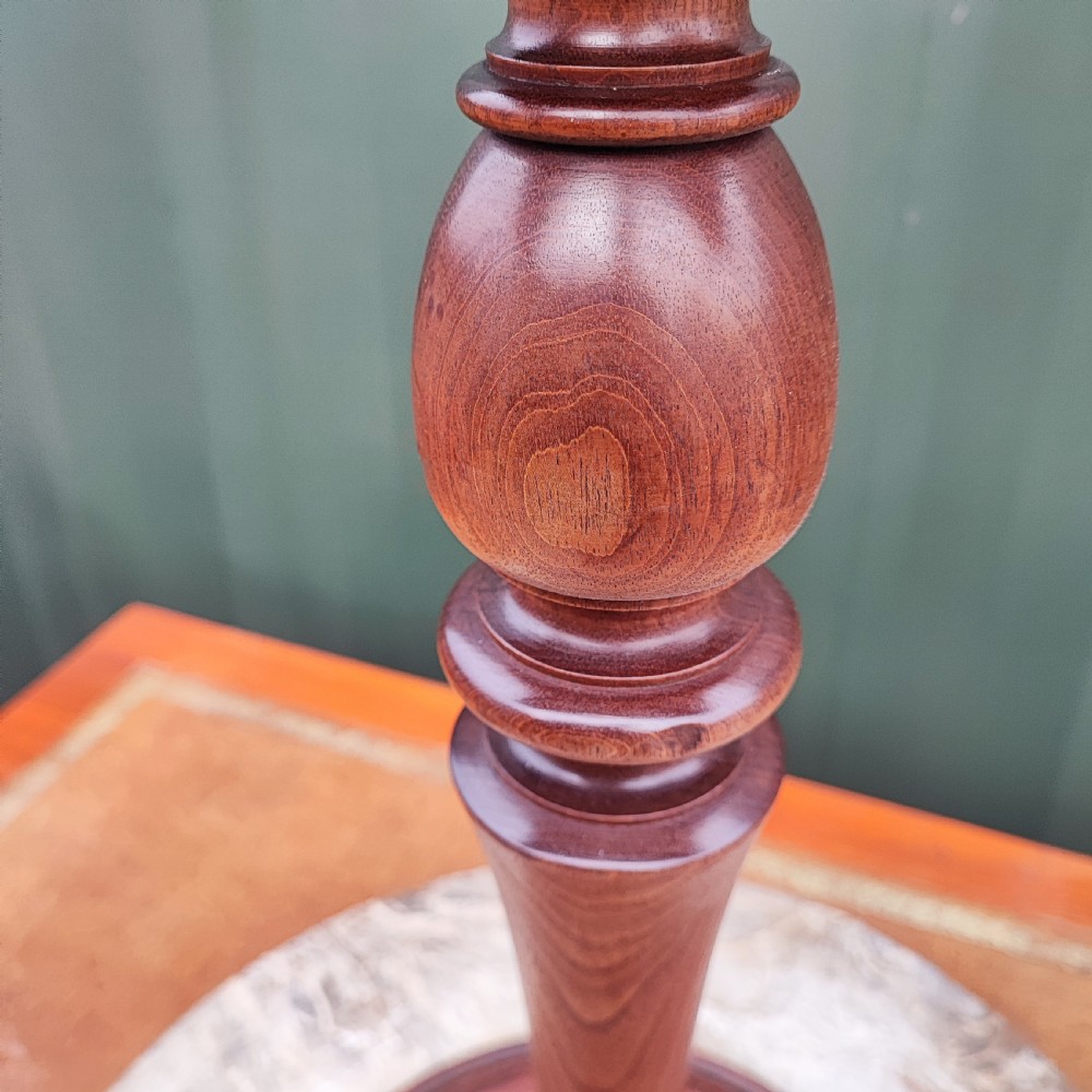 A circular grey variegated marble top side table featuring a turned wooden pedestal column and a tri-form base. View III