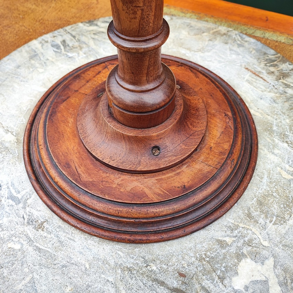 A circular grey variegated marble top side table featuring a turned wooden pedestal column and a tri-form base. View IV