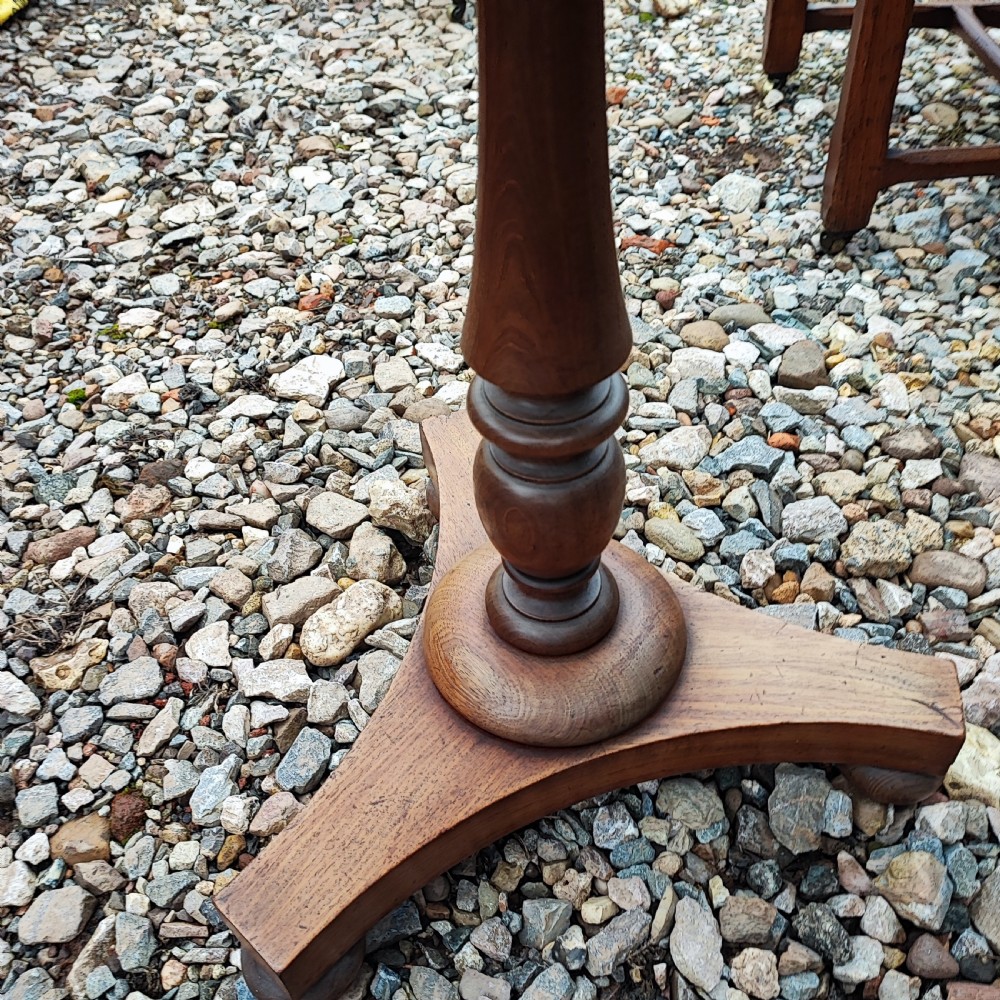 A circular grey variegated marble top side table featuring a turned wooden pedestal column and a tri-form base. View V