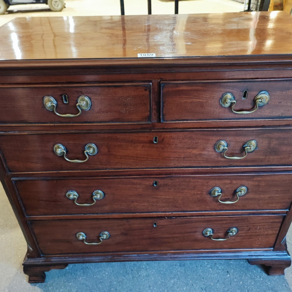 A Georgian mahogany chest of drawers with two short drawers over three long graduated drawers, finished with brass swan-neck handles and bracket feet. View III