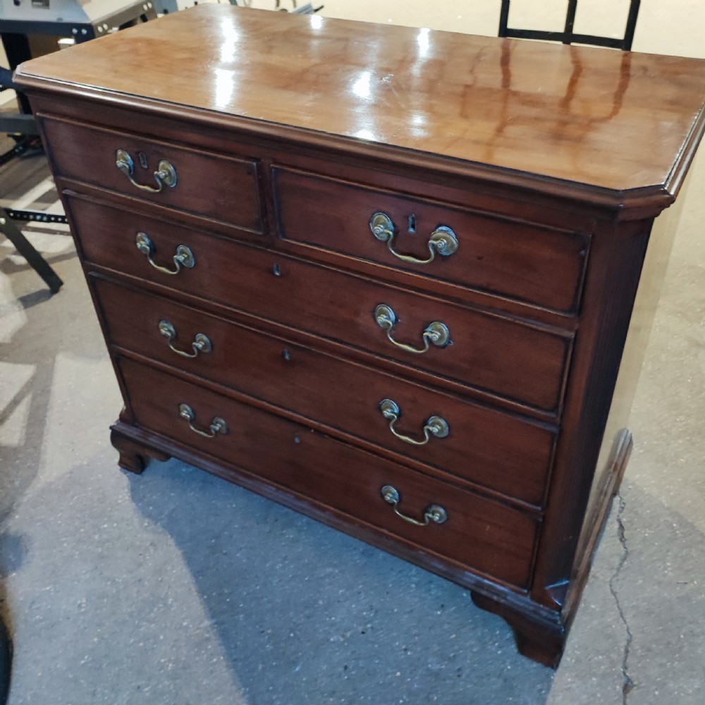 A Georgian mahogany chest of drawers with two short drawers over three long graduated drawers, finished with brass swan-neck handles and bracket feet. View VI