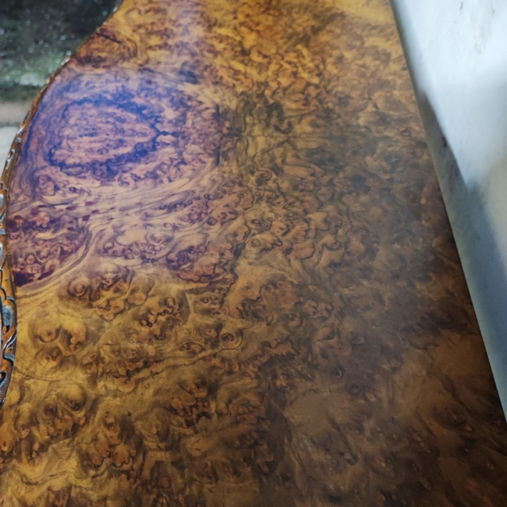 Victorian burr walnut fold-over card table featuring a serpentine top with carved apron details, supported by a central carved pedestal on four scroll-foot legs. View IV