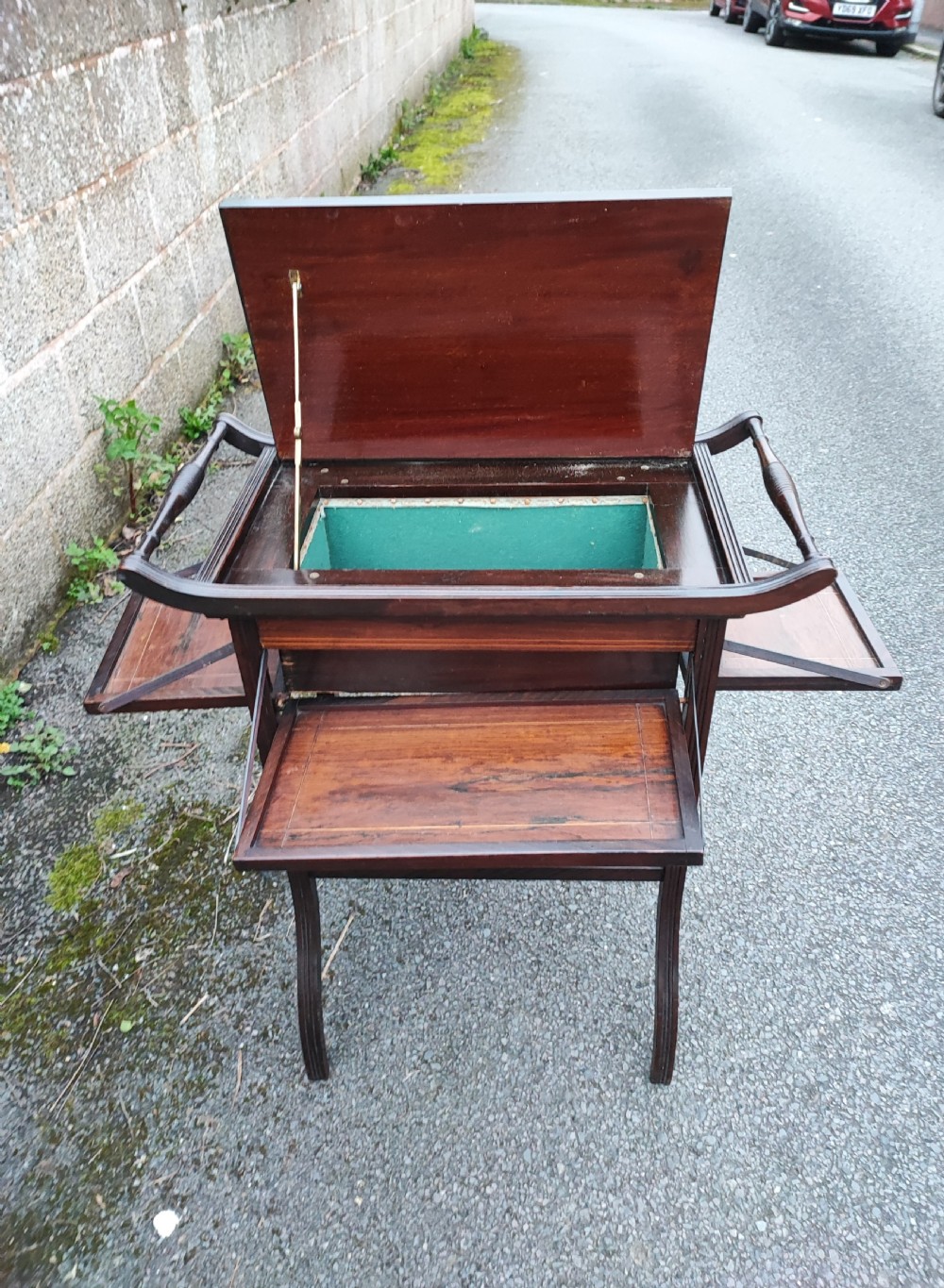 An antique rosewood work table featuring top marquetry inlay with a central sunburst motif, turned side handles, a lower shelf, and curved legs. View VII