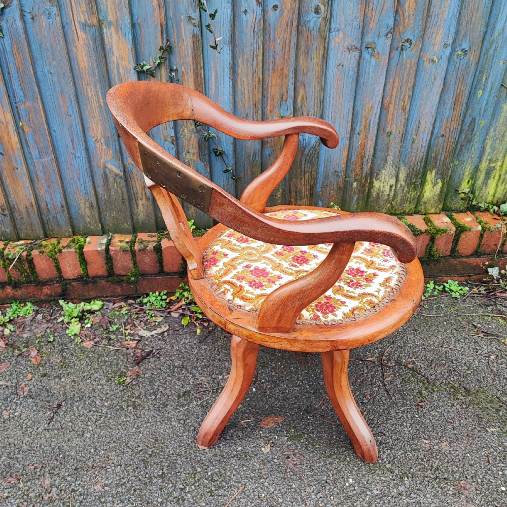 A Victorian mahogany revolving desk chair featuring a curved horseshoe armrest, a pierced central back splat, and an upholstered circular seat. View III