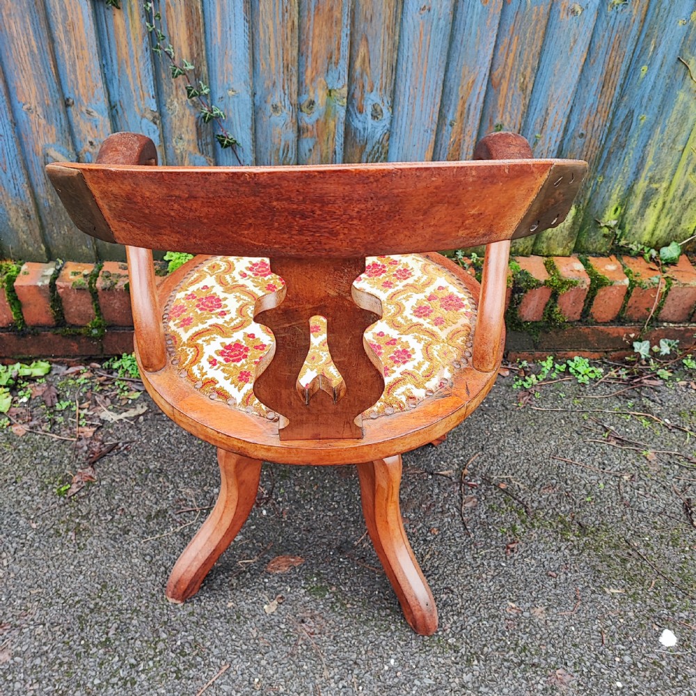 A Victorian mahogany revolving desk chair featuring a curved horseshoe armrest, a pierced central back splat, and an upholstered circular seat. View VII