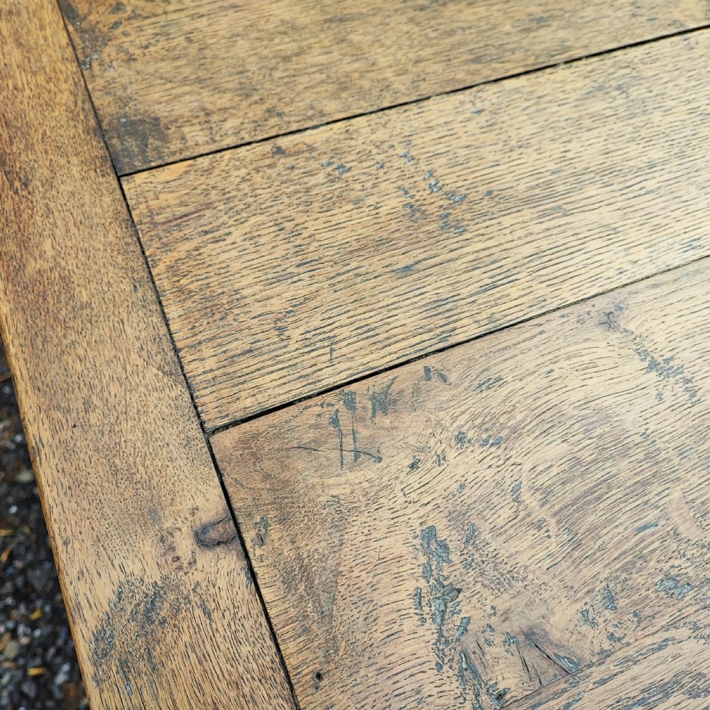 A long antique oak refectory table featuring a wide plank top with cleated ends and a trestle base secured with wooden keys. View II