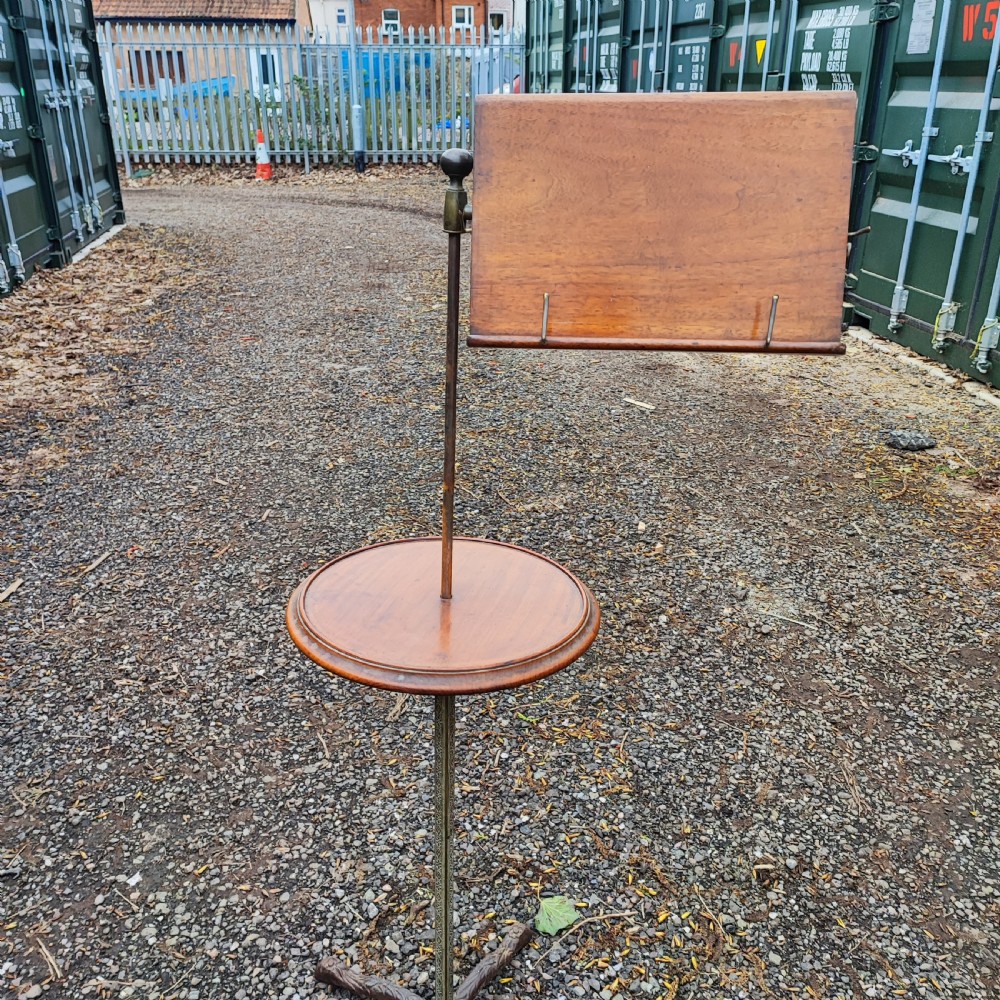 An antique Victorian adjustable mahogany reading stand featuring a revolving book rest with page holders, a secondary circular tray, and a telescopic brass stem on a cast iron base. View IV