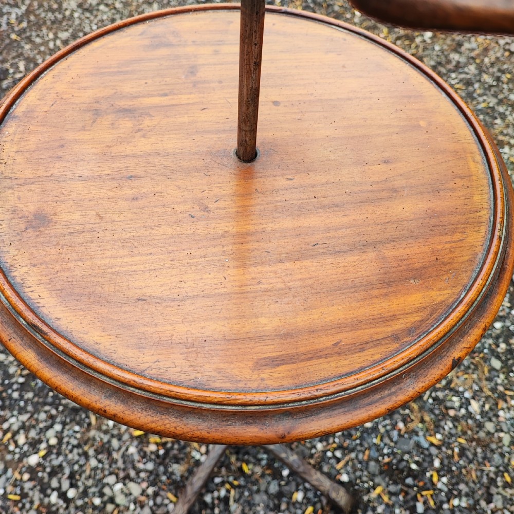 An antique Victorian adjustable mahogany reading stand featuring a revolving book rest with page holders, a secondary circular tray, and a telescopic brass stem on a cast iron base. View VII