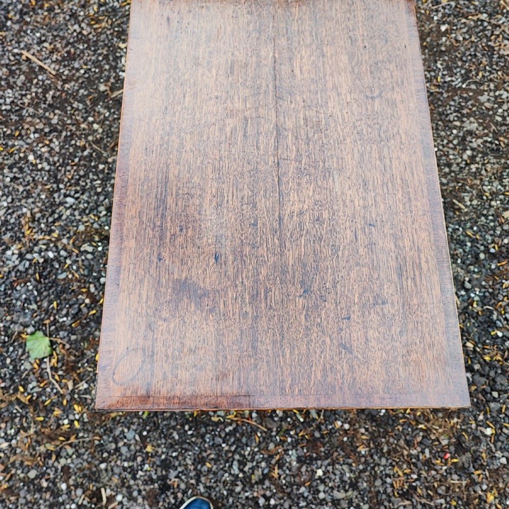 A Georgian dark oak lowboy side table featuring a rectangular top, three drawers with brass handles, inlaid stringing, corner spandrels, and straight tapering legs. View V