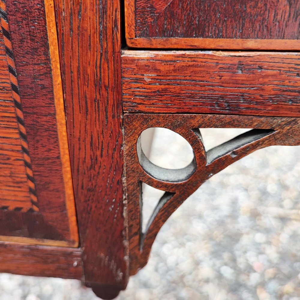 A Georgian dark oak lowboy side table featuring a rectangular top, three drawers with brass handles, inlaid stringing, corner spandrels, and straight tapering legs. View VI