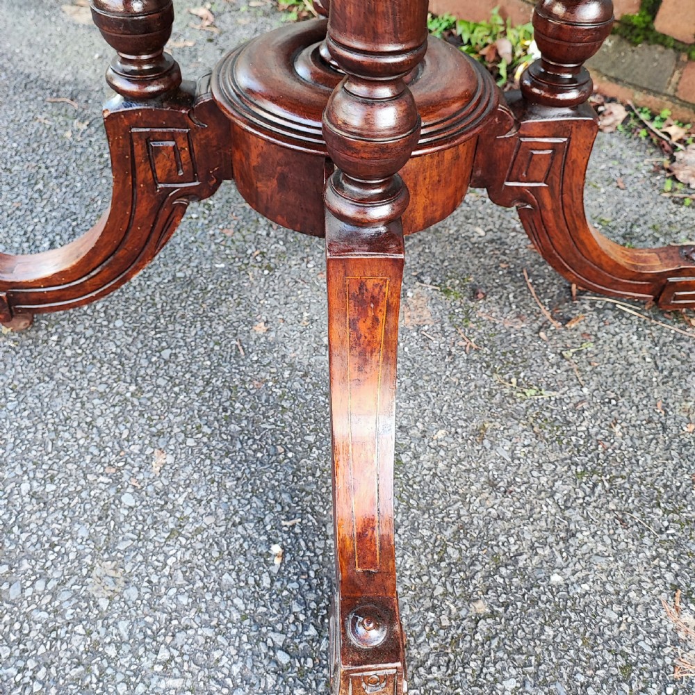 An octagonal Victorian centre table made of burr walnut featuring an inlaid floral marquetry border and a turned four-column pedestal base. View V