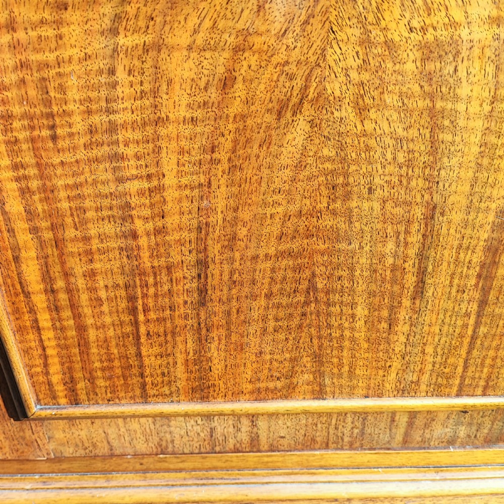 A warm brown walnut display cabinet featuring two upper glazed doors with astragal bars over two solid moulded lower doors. View VII