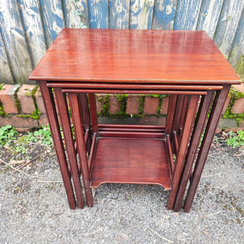 A set of three graduated Edwardian mahogany nesting tables with rectangular tops and slender square legs. View II