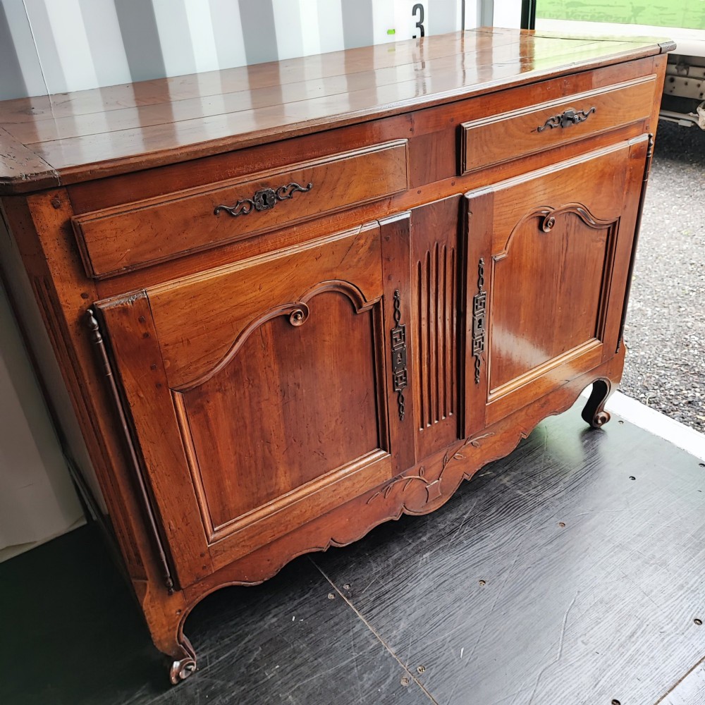 An 18th century French cherry wood side cabinet featuring two drawers above two carved panel doors with ornate metal escutcheons and cabriole feet. View II