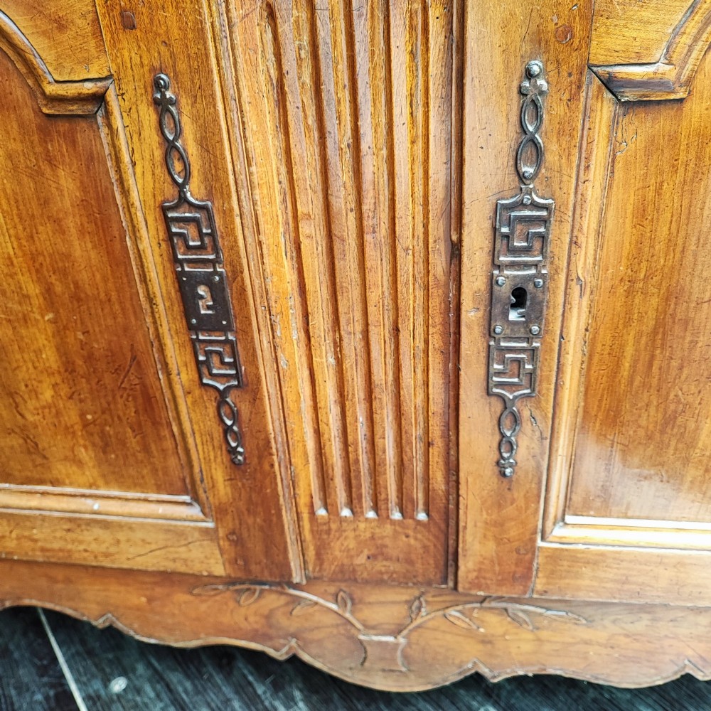 An 18th century French cherry wood side cabinet featuring two drawers above two carved panel doors with ornate metal escutcheons and cabriole feet. View IX