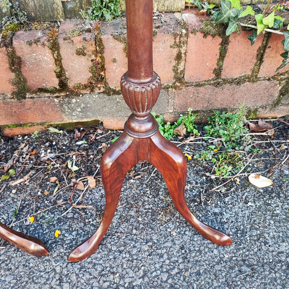 A matched pair of mahogany wine tables with circular dished tops, reeded turned stems, and cabriole tripod legs. View VI