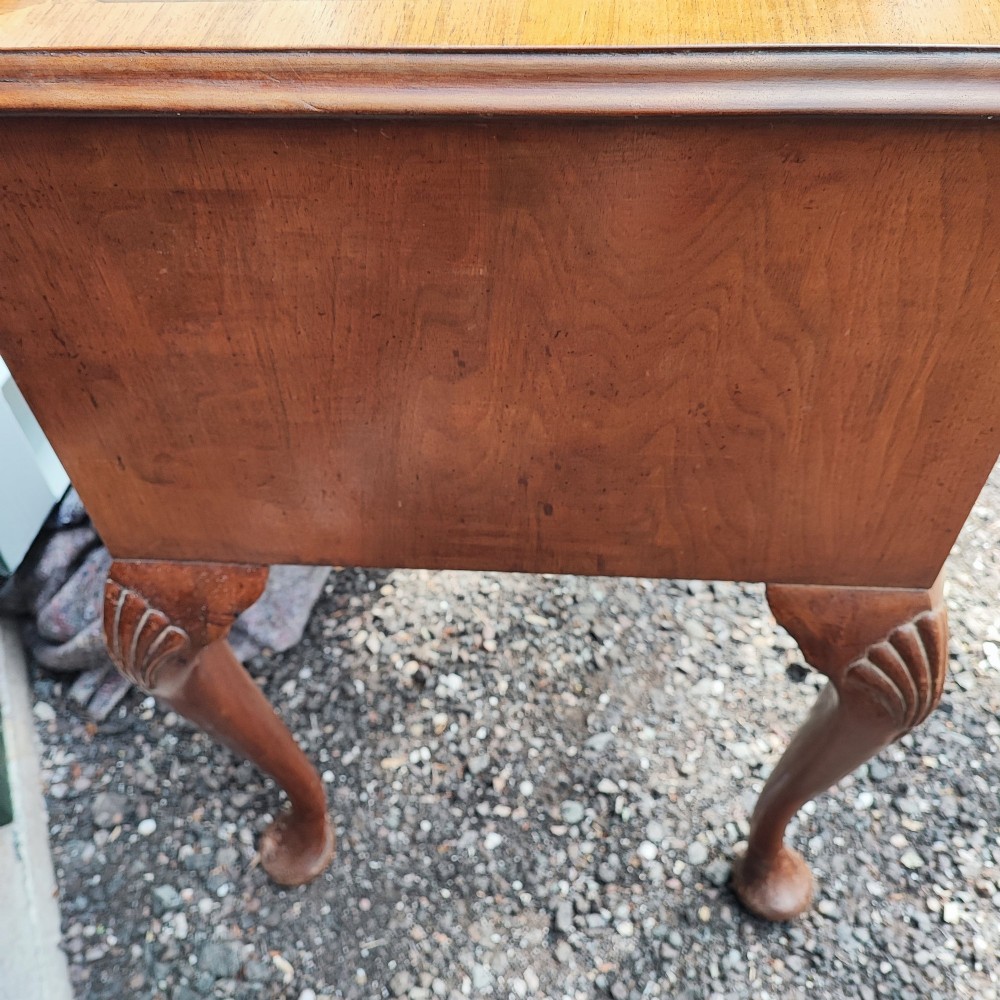 An antique burr walnut writing table featuring five drawers, brass handles, and carved cabriole legs. View VII