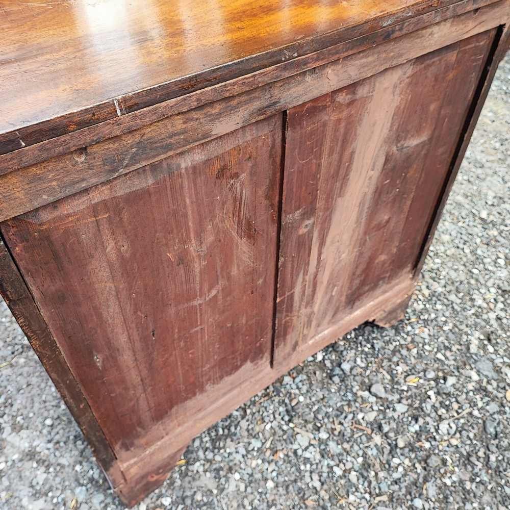 An antique Regency mahogany chest of drawers featuring four full-width drawers with brass oval handles and bracket feet. View II